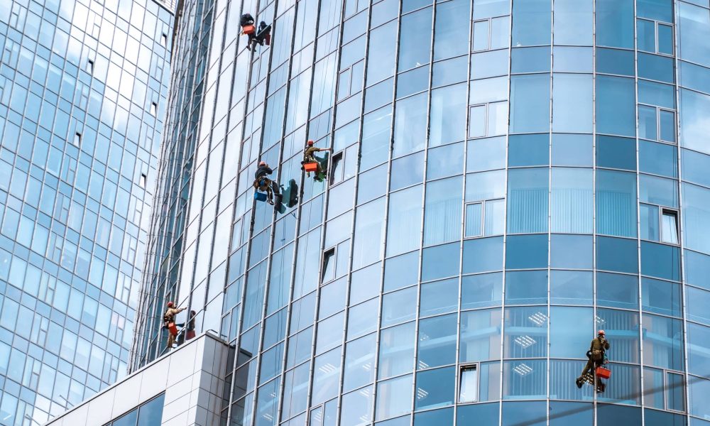 Several workers washing windows in the office building